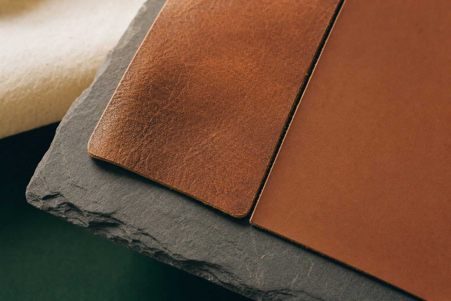 Two leather swatches side by side, one full grain with natural texture and one smooth coated top grain