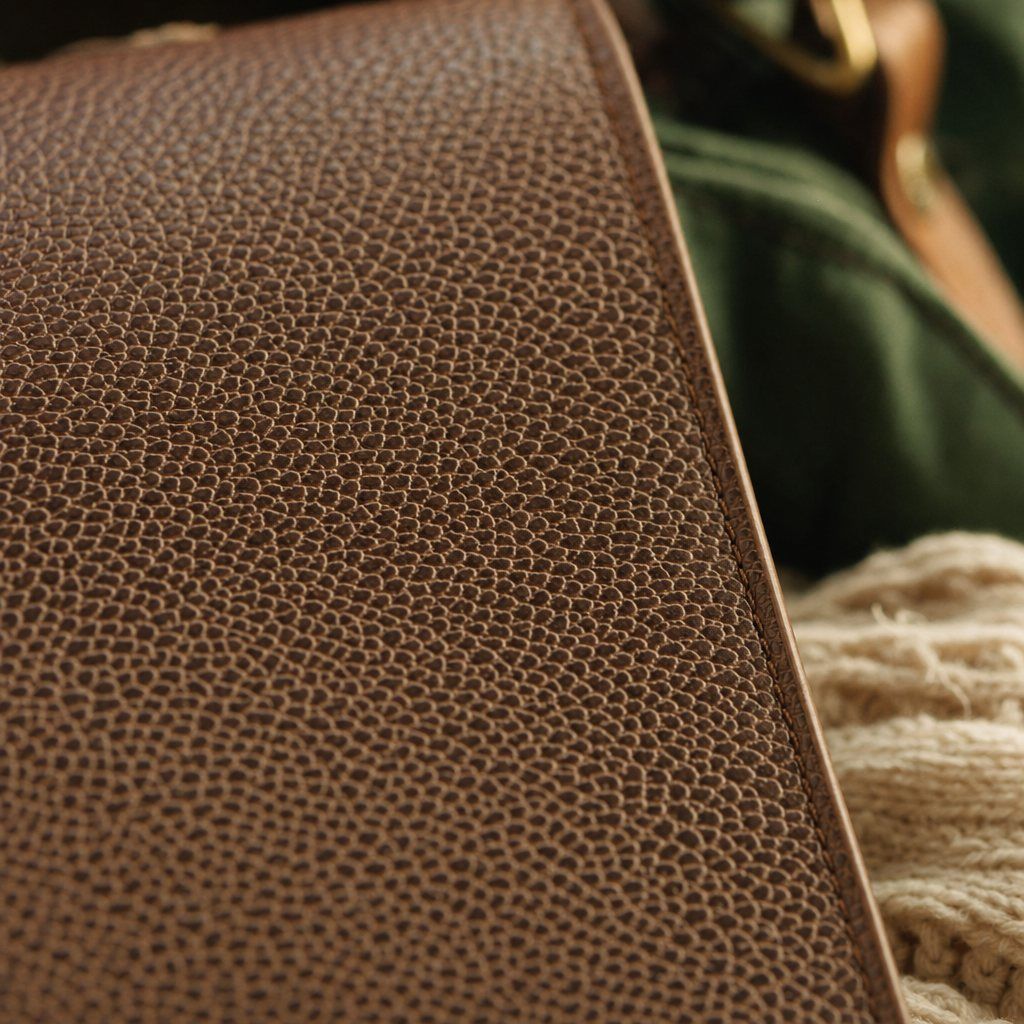 Close-up of corrected grain leather with a heavy pigmented finish and a regular embossed pebble pattern